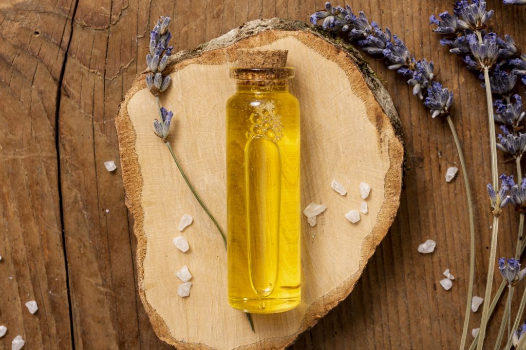 Flacon d’huile essentielle de lavande posé parmi des fleurs de lavande fraîche, symbole de relaxation naturelle et de bienfaits anti-stress